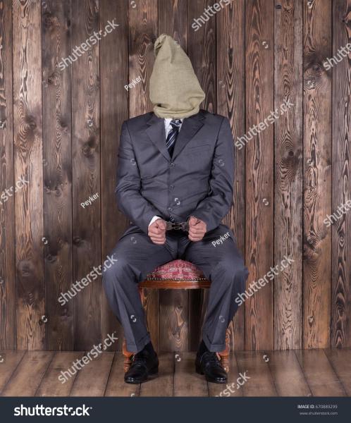 stock-photo-captive-a-man-with-a-bag-on-his-head-a-man-in-handcuffs-670889299.jpg